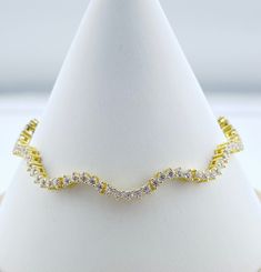 Ready to stand out in the crowd? Introducing our Wavy Style CZ Tennis Bracelet, a distinctive and unparalleled piece in the realm of demi-fine jewelry. Uniquely designed, this bracelet stands apart with its avant-garde wavy pattern, setting it apart from the ordinary. 1 Micron Gold plating for long durability! Push clasp fastening with Safety clasp. 14k Gold over 925 Sterling Silver. Bracelet measures 7". Elegant Adjustable Wavy Bracelets, Adjustable Wavy Bracelet As Gift, Adjustable Wavy Bracelets As Gift, Elegant Wavy Oyster Bracelet, Elegant Spiral Bracelets For Party, Elegant Adjustable Spiral Bracelet, Bracelet Stands, Wavy Pattern, Wavy Style