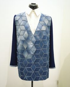 a mannequin wearing a blue sweater and white shirt with an argyle pattern on it