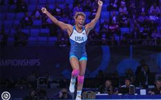 a woman is jumping in the air with her arms up and legs spread wide as she celebrates