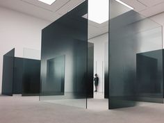 an empty room with glass walls and a person standing in the middle