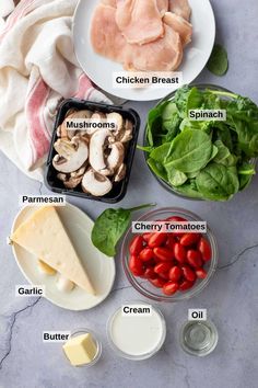 ingredients to make chicken broth laid out on a marble counter top, including mushrooms, spinach, cherry tomatoes, cheese, and parmesan