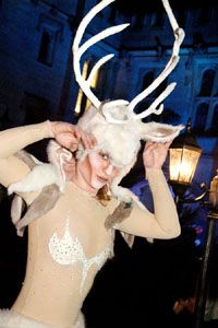 a woman dressed in white is dancing at night