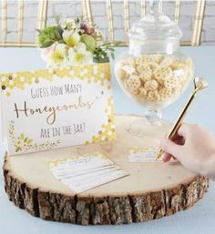 a person writing on a note next to a jar of honeycombs and a card