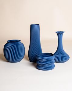 three blue vases sitting next to each other on a table