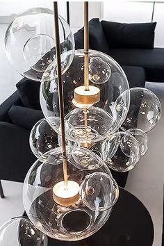 a living room filled with black furniture and lots of glass balls on top of it