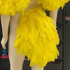 mannequins dressed in bright yellow feathery clothing