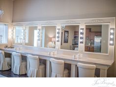 a room that has some lights on and chairs in front of the counter with stools