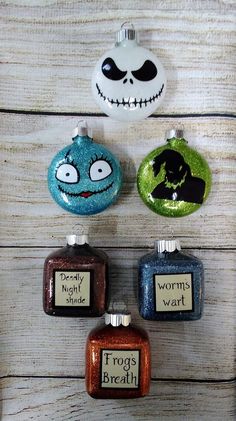 four ornaments with faces and words on them