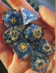 the sun and moon dices are on display in someone's hand with their fingers