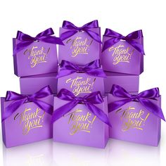 six purple thank you gift boxes with gold lettering and a bow on the front, set against a white background