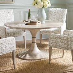 a dining room table with white chairs around it