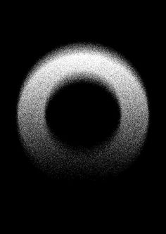 a black and white photo of a circular object in the dark space with light coming from it