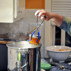 a person using a pair of tongs to stir something in a pot on the stove