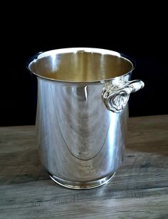 a silver pot sitting on top of a wooden table