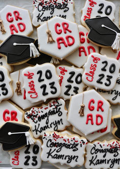 decorated cookies with graduation caps and tassels are displayed on a tray for display