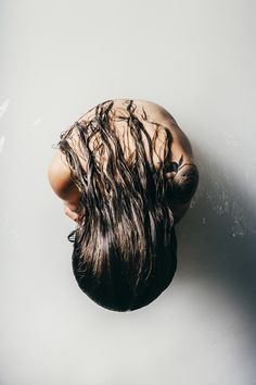 an overhead view of a woman's head with long hair on her face and back