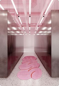 an empty hallway with pink rugs on the floor and lights hanging from the ceiling