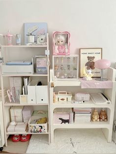 a room filled with lots of toys and books on top of a white shelf next to a wall