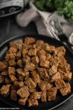 meat cubes on a black plate with parsley in the backgroung