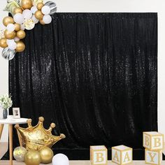 a black and gold baby shower backdrop with balloons