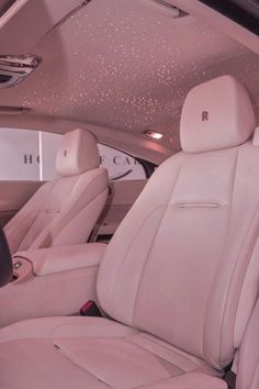 the interior of a luxury car with white leather seats and sparkling lights on the ceiling