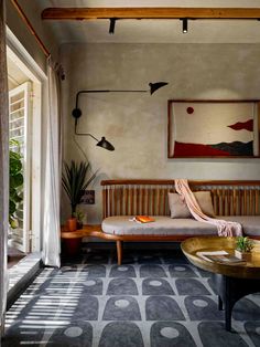 a living room with a couch, coffee table and potted plant in the corner