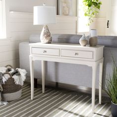 a living room with a couch, table and potted plant on the floor next to it