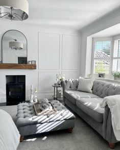 a living room filled with furniture and a fire place next to a mirror on the wall