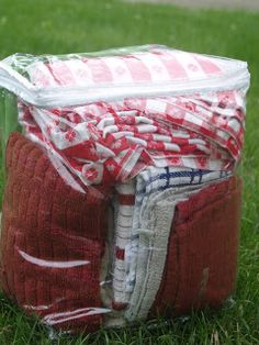 a bag filled with red and white towels on top of green grass