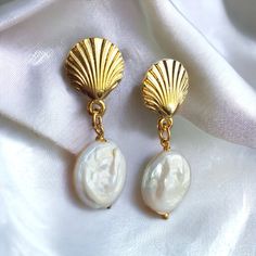 Elevate your elegance with our Teardrop Earrings, where the beauty of the sea meets timeless style. These handcrafted earrings feature a unique design, with a tear-shaped gold-plated seashell brass charm that dangles gracefully below a lustrous pearl drop. Materials : Gold Plated Seashell , Pearl Length : 4.5 centimetres (1.77 inches) Comfortable to Wear: These earrings are lightweight and comfortable, making them suitable for daily wear or special occasions. *Avoid contact with water, perfumes and other chemicals. Pearl Drop Shell As A Gift, Pearl Charm Shell Earrings Gift, Shell Earrings With Pearl Charm Gift, Shell-shaped Clip-on Earrings For Gift, Elegant Shell Drop Earrings, Elegant Pearl Charm Earrings With Shell, Wedding Pearl Drop Earrings In Shell Shape, Shell-shaped Pearl Charm Earrings As Gift, Elegant Shell Dangle Earrings