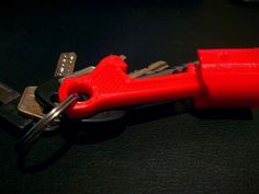 a pair of red keys are attached to a key fobl on a black surface