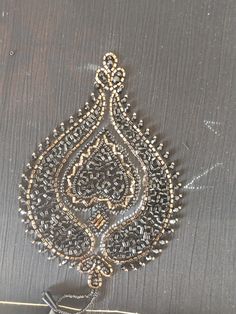 an intricately designed wall hanging on the side of a wooden door with metal handles