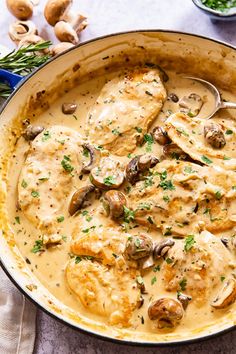 a pan filled with chicken and mushrooms covered in gravy