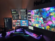 three computer monitors sitting next to each other in front of a wall with multiple screens on it