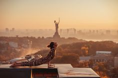 a woman doing yoga on top of a building