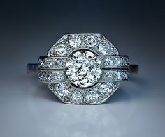 an antique diamond ring with two rows of diamonds on the band and center stone in the middle