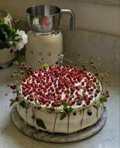 a cake with white frosting and strawberries on top is sitting on a counter