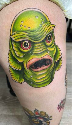 a close up of a person's leg with a tattoo on it and an image of a creature