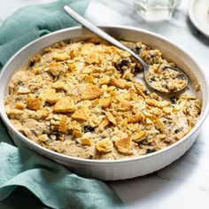 a casserole dish with bread and raisins in it on a table