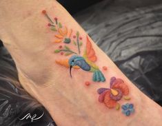 a colorful tattoo on the foot of a woman