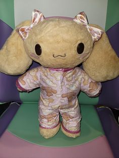 a stuffed animal sitting on top of a purple and green chair with its ears up