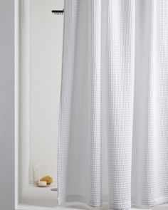 a white shower curtain in a bathroom