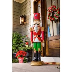 a nutcracker statue sitting in front of a house with christmas decorations on the porch