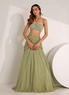 Turn heads with this stunning Mint Green Cowl Skirt and Embellished Bralette set. Crafted from shimmer chiffon and lycra, the mint green bralette features intricate crystal embroidery, adding a touch of glamour with a hint of mystery. Teamed with the flowing cowl skirt, which drapes effortlessly, the outfit moves with an almost elusive grace. Contemporary look, ideal for Sangeet, weddings, or evening events. Composition : Skirt, Blouse - Shimmer Chiffon, Shantoon, and Lycra Care: Dry Clean Only and Vacuum Storage This product can be customized for sleeves, blouse length and neckline Delivery : 4-6 weeks as the product is hand crafted. Check Size Guide or choose MySize for free customisation (All Sizes above XL can be made at 15% additional cost) For more information and sizes please contac Cowl Skirt, Green Bralette, Crystal Embroidery, Skirt Blouse, Vacuum Storage, Sleeves Blouse, The Outfit, Blouse Length, Mint Green