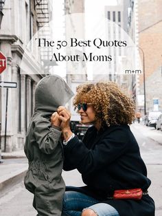 a woman sitting on the ground with a child in her lap and text overlay that reads, the 50 best quotes about moms