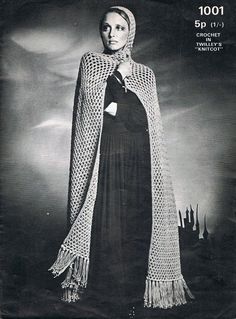 a woman wearing a crochet shawl and standing in front of a castle