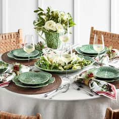 the table is set with green plates and silverware