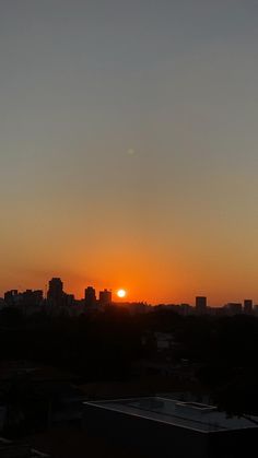 the sun is setting over a city skyline