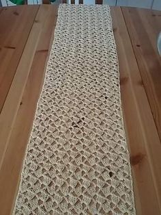 a wooden table with a crocheted runner on it