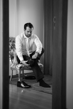 a man sitting in a chair looking at his shoes